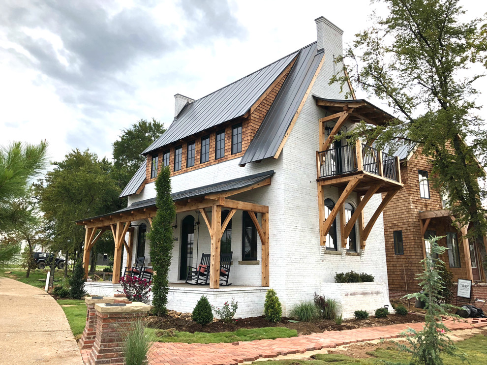 Diseño de fachada de casa blanca tradicional renovada de tamaño medio de tres plantas con revestimiento de ladrillo, tejado a dos aguas y tejado de metal