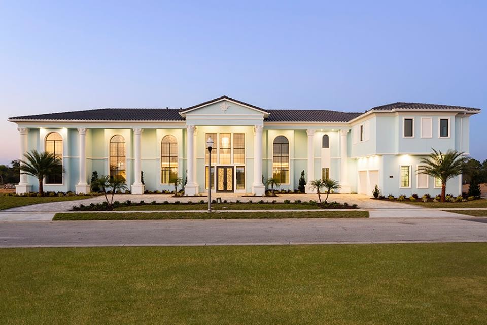 Example of a huge transitional blue two-story stucco exterior home design in Orlando