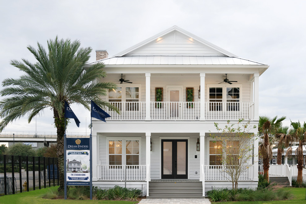 Стильный дизайн: двухэтажный, белый дом среднего размера в морском стиле с облицовкой из ЦСП и полувальмовой крышей - последний тренд