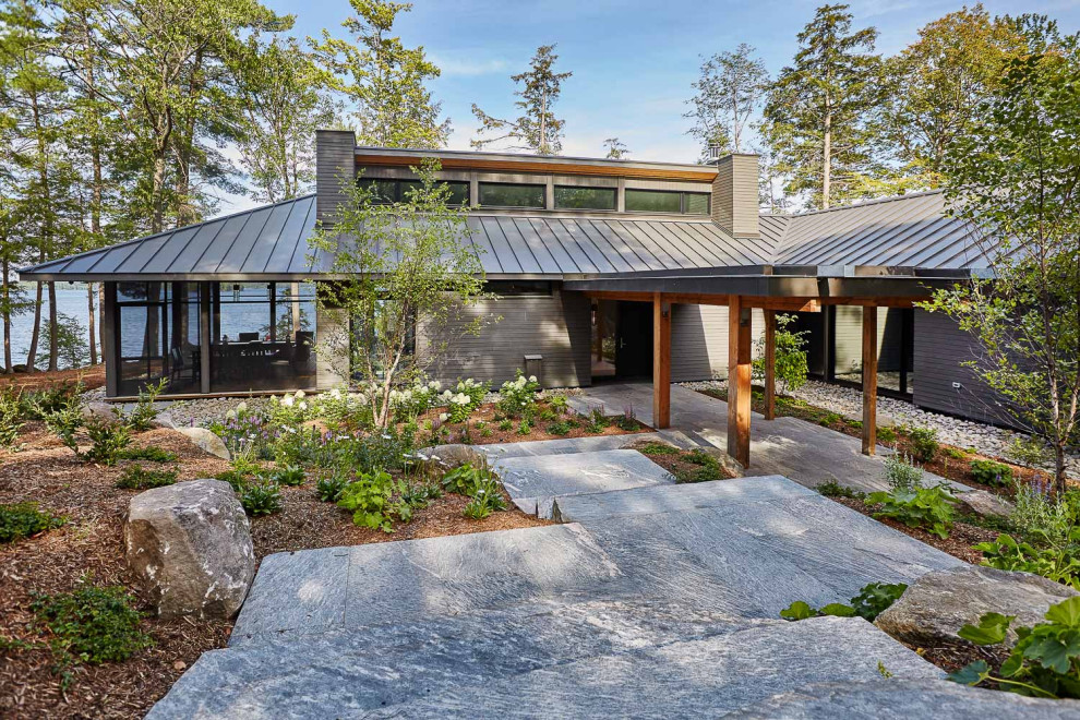 Example of a mid-sized mountain style gray one-story glass house exterior design in Toronto with a hip roof and a metal roof