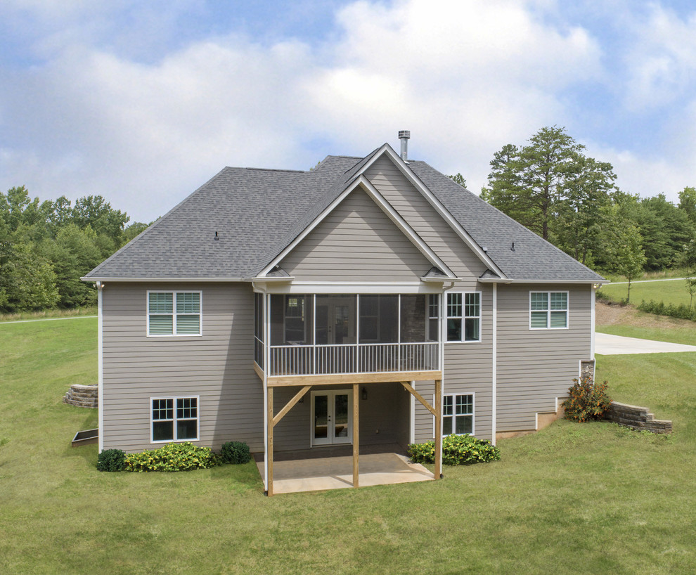 Imagen de fachada de casa de estilo americano de una planta con revestimientos combinados, tejado a cuatro aguas y tejado de teja de madera