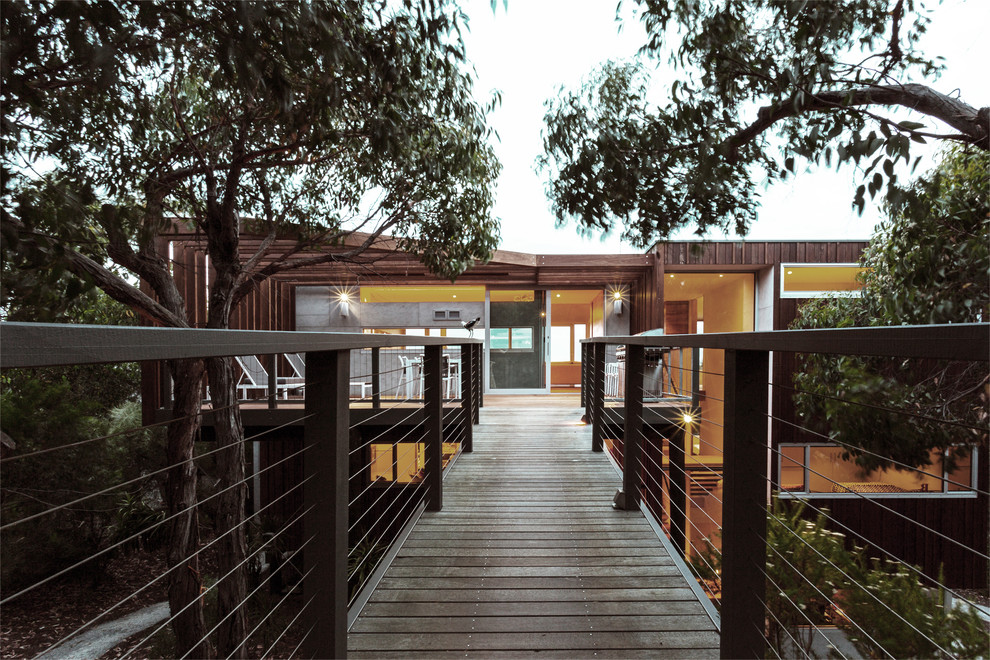 Immagine della villa contemporanea con rivestimento in legno, tetto piano e copertura in metallo o lamiera