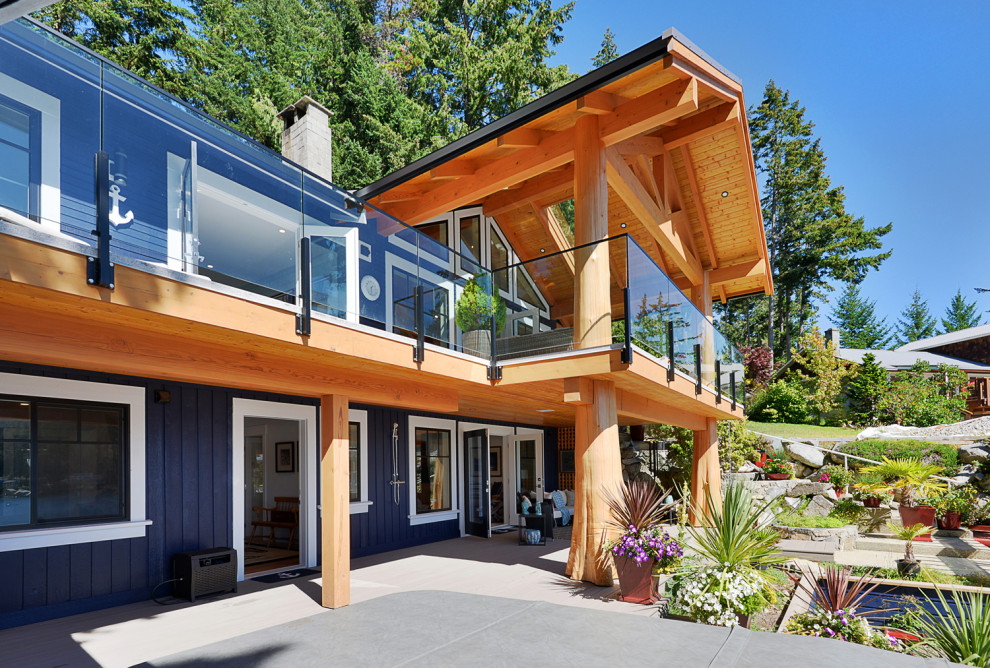 This is an example of a medium sized and blue beach style two floor detached house in Vancouver with vinyl cladding, a pitched roof, a metal roof, a black roof and board and batten cladding.
