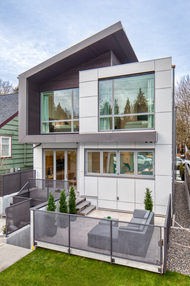 Réalisation d'une petite façade de maison blanche design à un étage avec un revêtement mixte, un toit en métal et un toit en appentis.