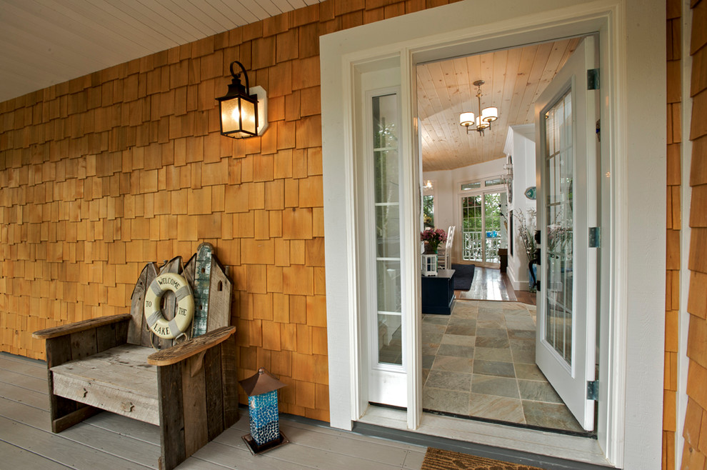 Medium sized and brown contemporary two floor house exterior in Vancouver with wood cladding and a hip roof.