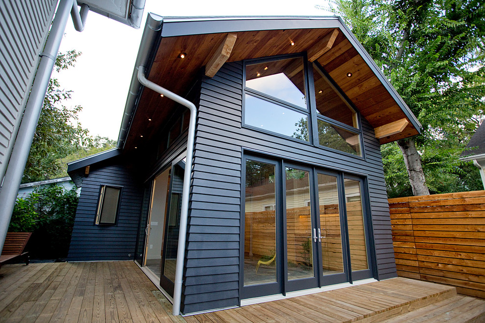 Пример оригинального дизайна: маленький, двухэтажный, синий дом в современном стиле с облицовкой из ЦСП для на участке и в саду