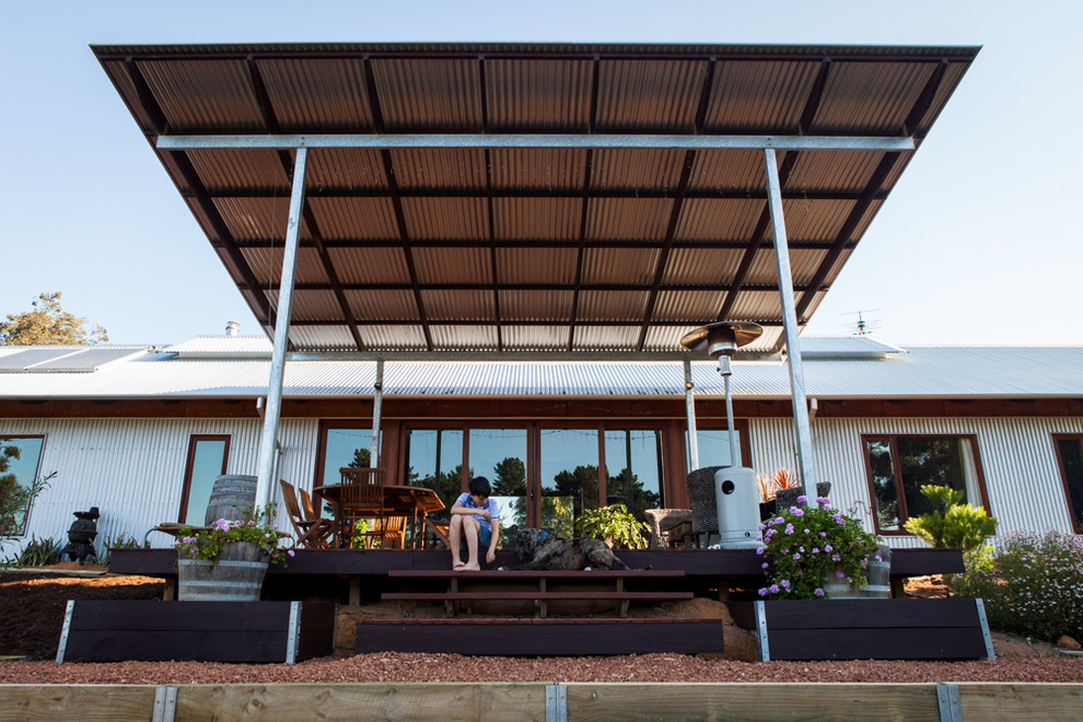Стильный дизайн: одноэтажный дом среднего размера в стиле кантри с облицовкой из металла и двускатной крышей - последний тренд