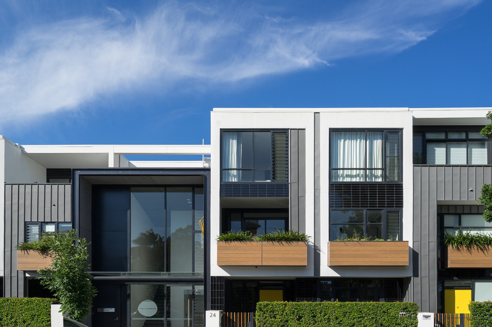 Свежая идея для дизайна: большой, трехэтажный многоквартирный дом в стиле модернизм с облицовкой из металла и плоской крышей - отличное фото интерьера