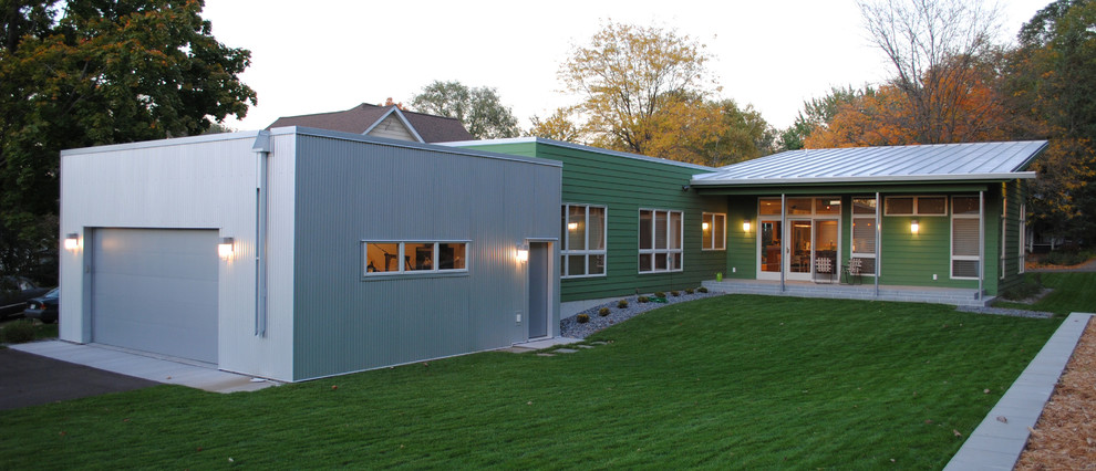 Свежая идея для дизайна: одноэтажный, зеленый дом среднего размера в стиле модернизм с облицовкой из металла и плоской крышей - отличное фото интерьера