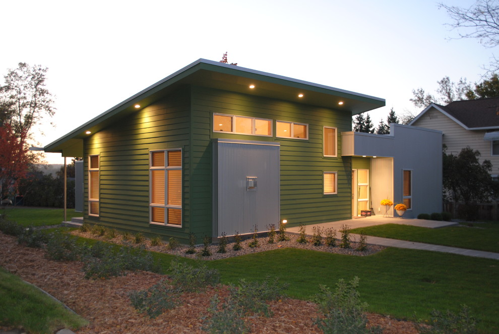 Immagine della facciata di una casa verde moderna a un piano di medie dimensioni con rivestimento in metallo e tetto piano