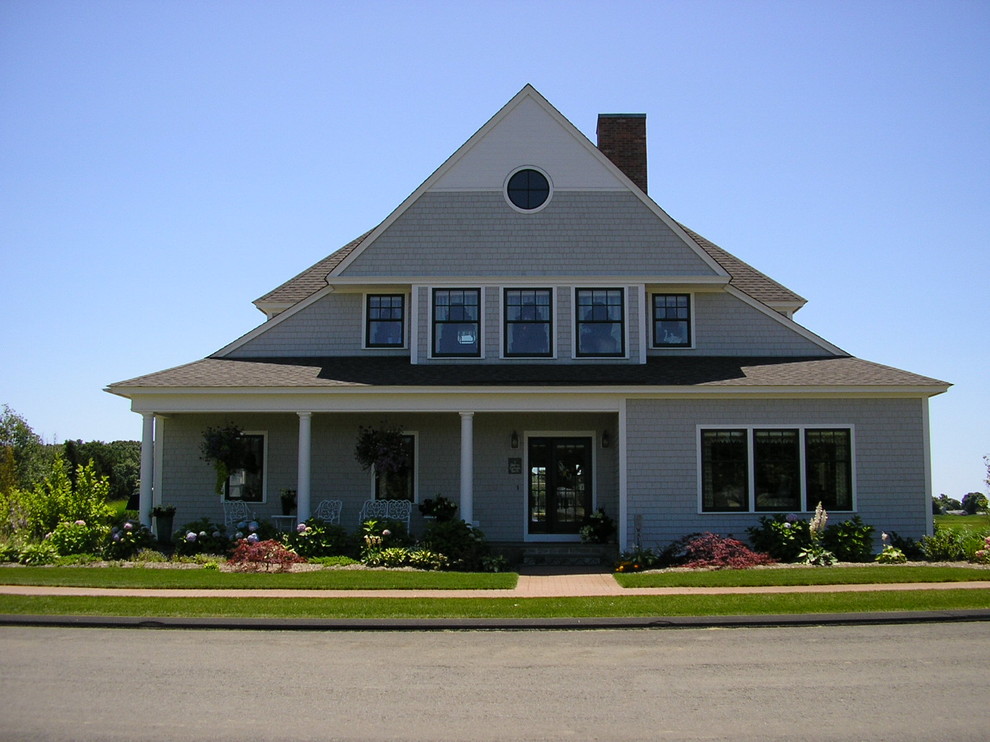 Cette photo montre une façade de maison grise bord de mer en bois de taille moyenne et à un étage avec un toit à deux pans et un toit en shingle.