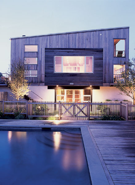 Photo of a large and brown modern house exterior in New York with three floors, wood cladding and a hip roof.