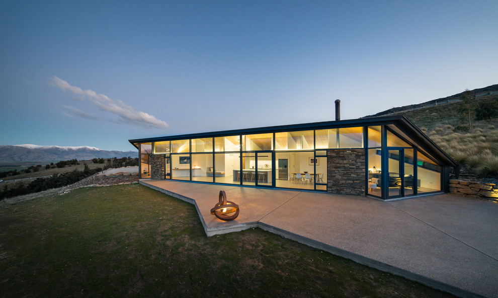 Inspiration pour une façade de maison minimaliste en verre de plain-pied avec un toit en appentis.