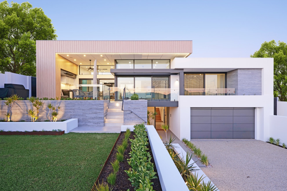 Cette image montre une façade de maison blanche design de taille moyenne et à un étage avec un toit plat, un revêtement mixte et un toit en métal.