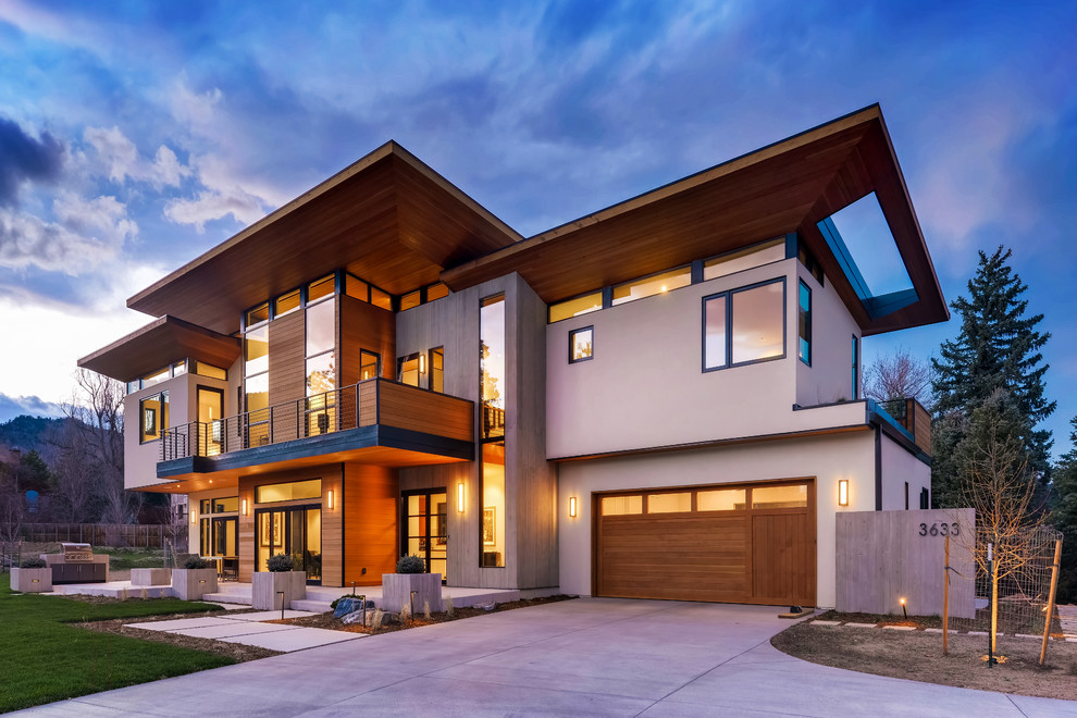 Example of a mid-sized brown two-story concrete exterior home design in Denver with a mixed material roof