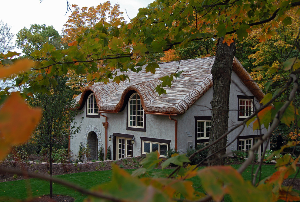 Idee per la facciata di una casa beige country con rivestimento in stucco e tetto a capanna