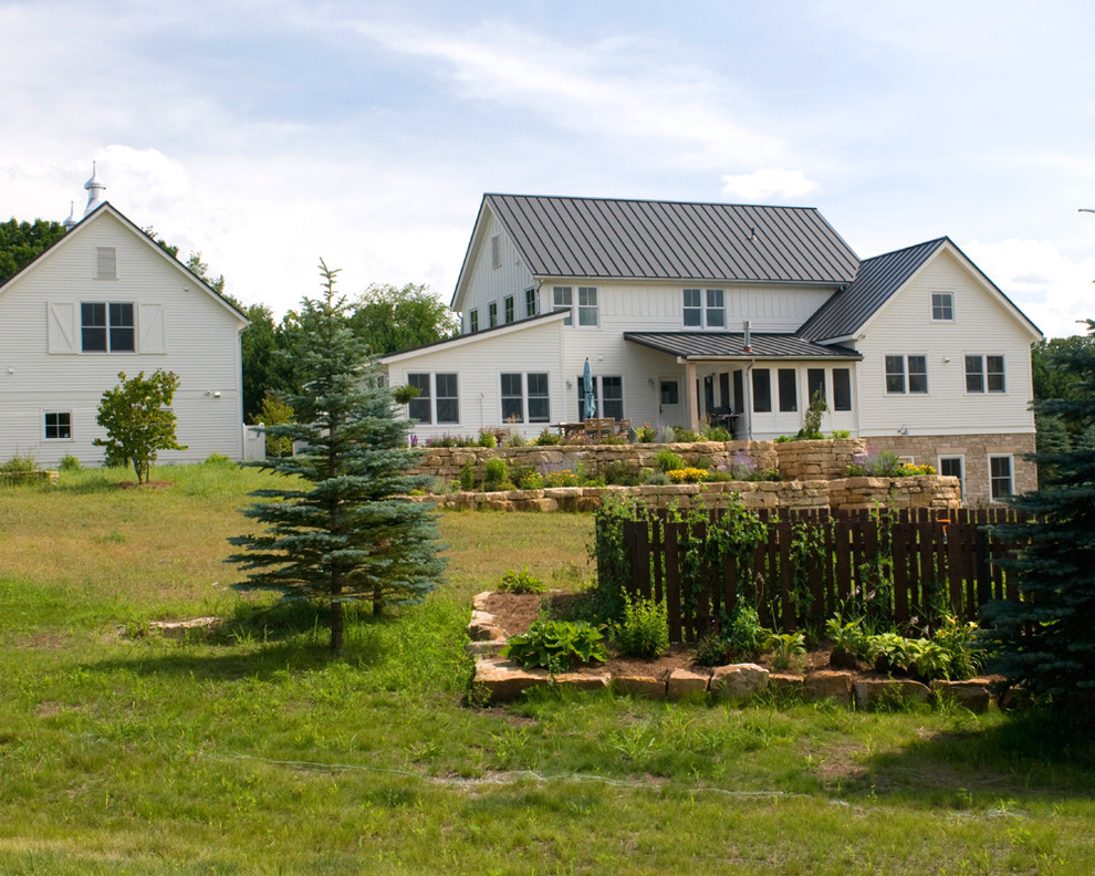 Cette image montre une façade de maison blanche rustique de taille moyenne et à un étage avec un revêtement mixte, un toit en appentis et un toit en métal.