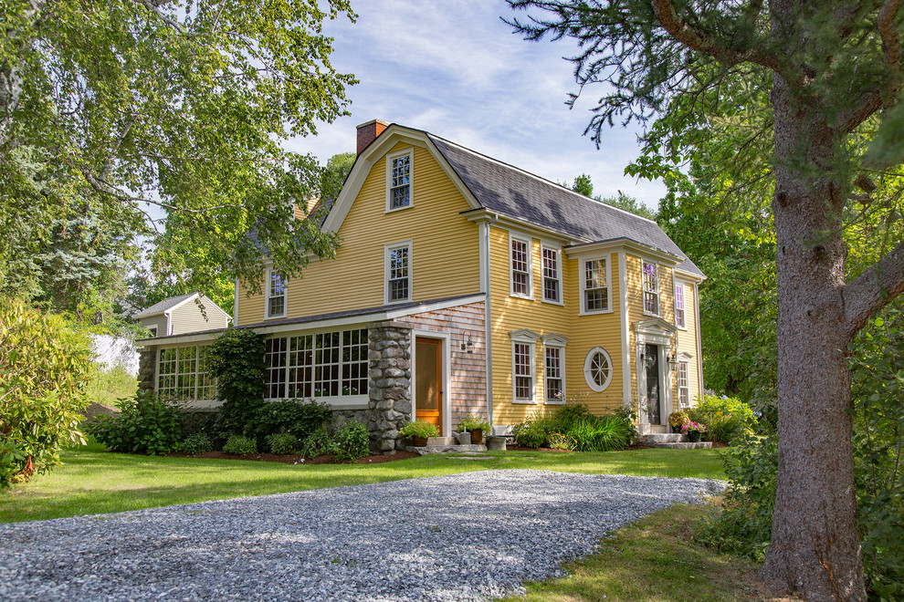 Large country yellow three-story wood exterior home idea in Boston