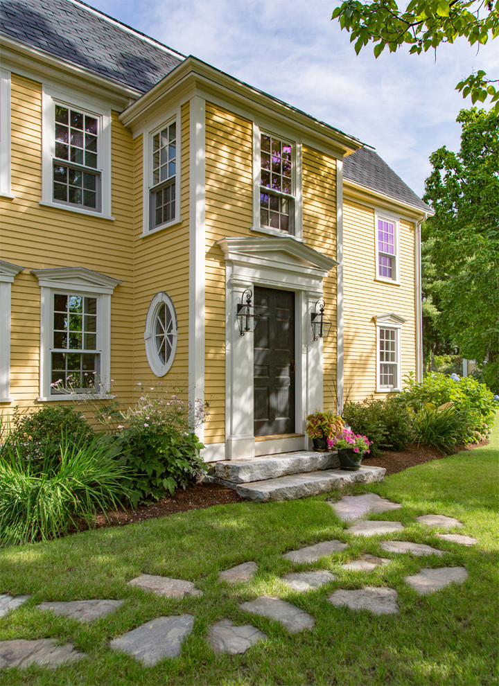 ボストンにあるカントリー風のおしゃれな家の外観 (黄色い外壁) の写真