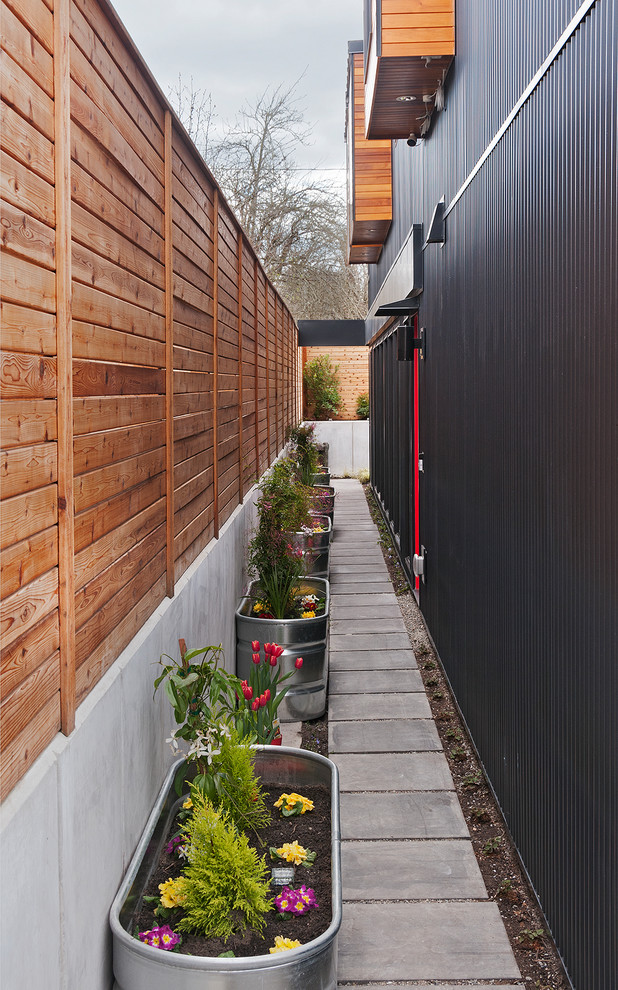 Modelo de fachada de casa negra minimalista pequeña de dos plantas con revestimiento de metal y tejado de metal