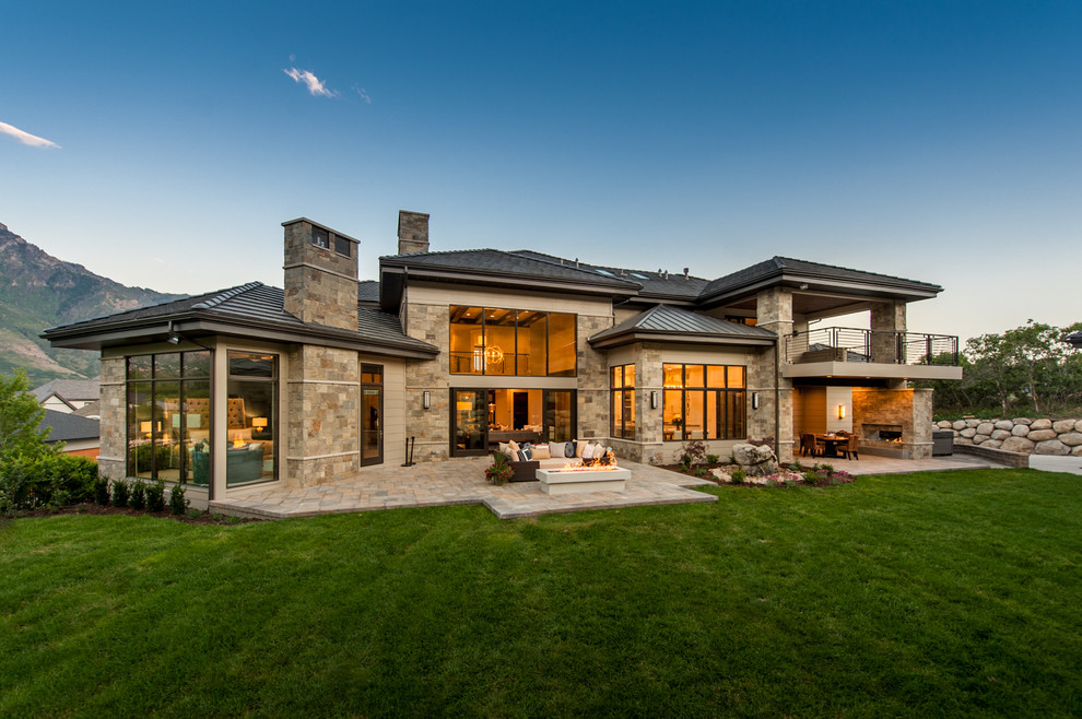 Стильный дизайн: двухэтажный, коричневый дом среднего размера в стиле неоклассика (современная классика) с облицовкой из камня и вальмовой крышей - последний тренд