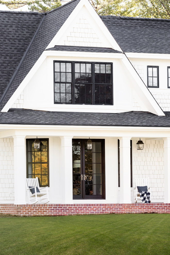 Aménagement d'une grande façade de maison blanche classique en bois à un étage avec un toit à deux pans et un toit en shingle.