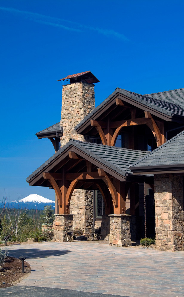 Example of a large mountain style beige two-story stone exterior home design in Other