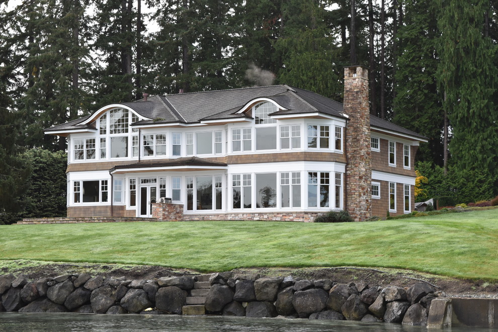 Imagen de fachada de casa marrón tradicional de dos plantas con tejado a cuatro aguas