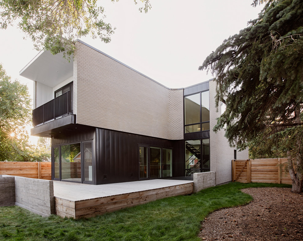 Inspiration för mellanstora moderna grå hus, med två våningar, tegel, platt tak och tak i mixade material