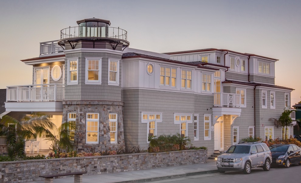 Diseño de fachada beige marinera grande de dos plantas con revestimientos combinados y tejado plano