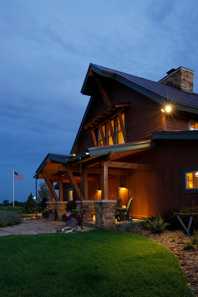 Large mountain style brown two-story wood exterior home photo in Omaha