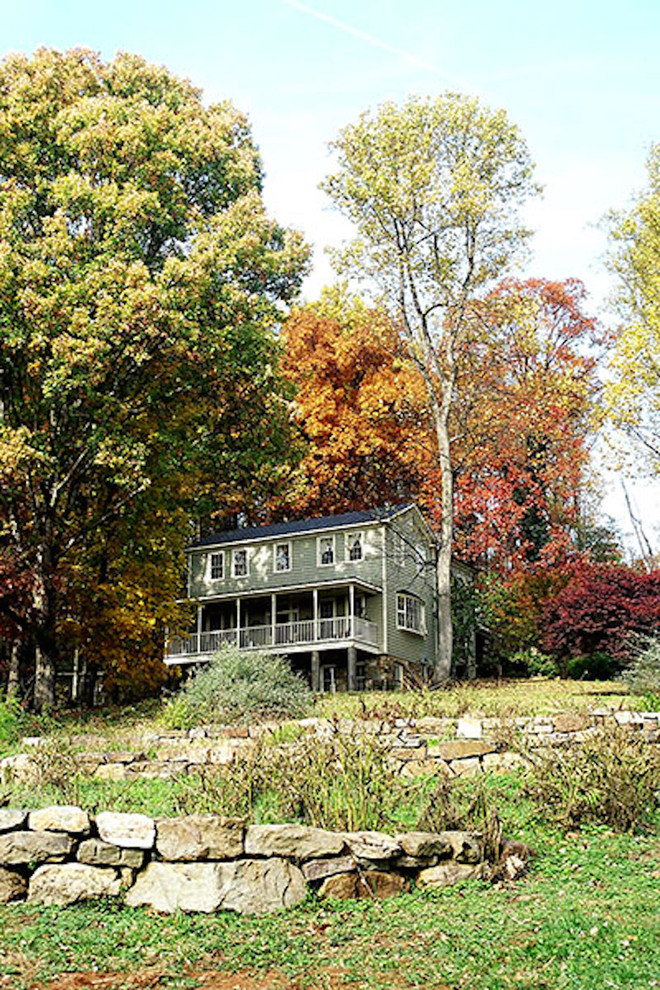 Esempio della facciata di una casa verde country a tre piani di medie dimensioni con rivestimento in legno