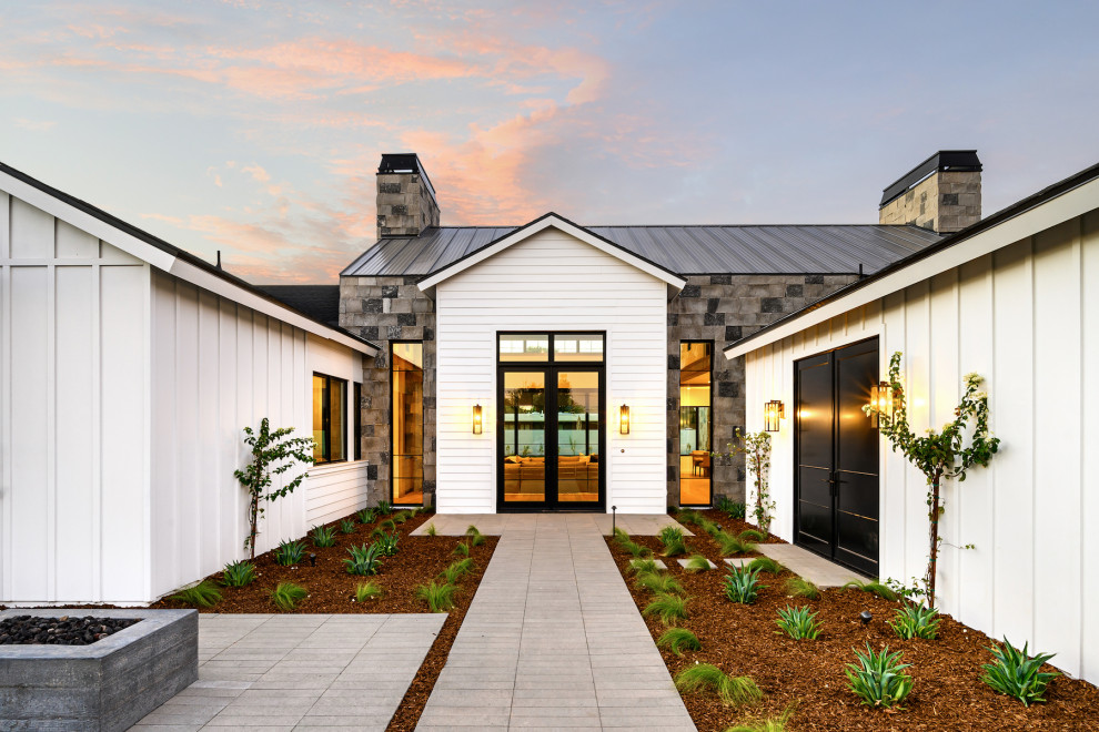 Idee per la villa grande bianca country a un piano con rivestimento in legno, tetto a capanna e copertura in metallo o lamiera