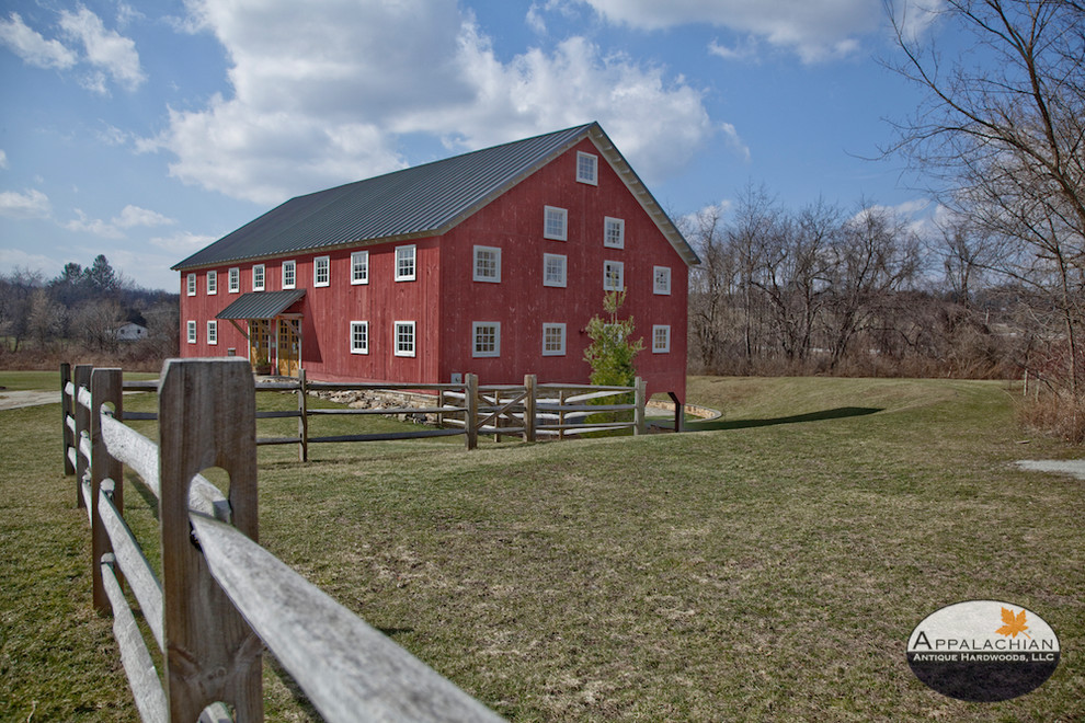 Cette photo montre une façade de maison rouge montagne en bois de taille moyenne et à un étage avec un toit en métal.