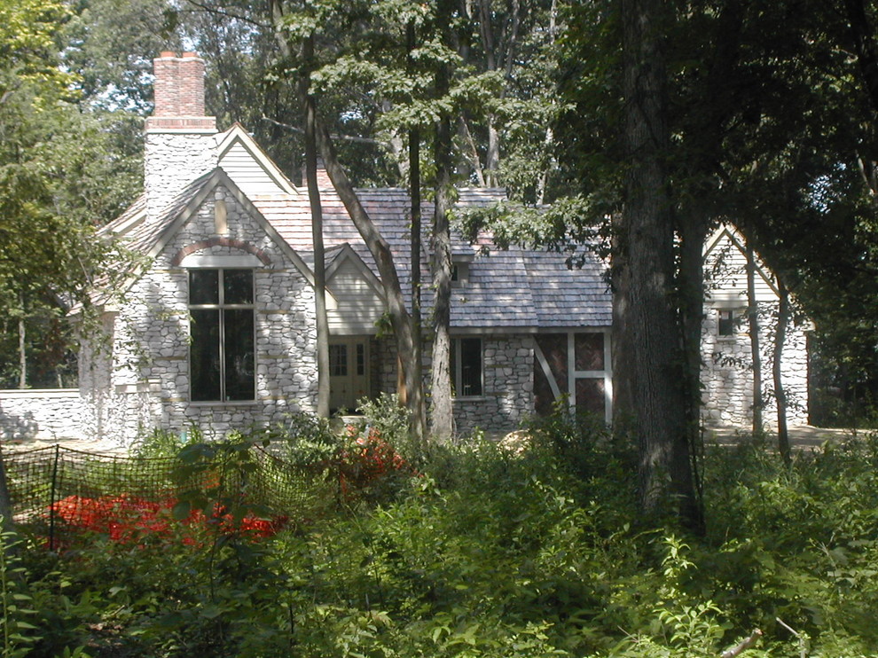 Exemple d'une façade de maison grise chic en pierre de taille moyenne et de plain-pied avec un toit à deux pans et un toit en shingle.