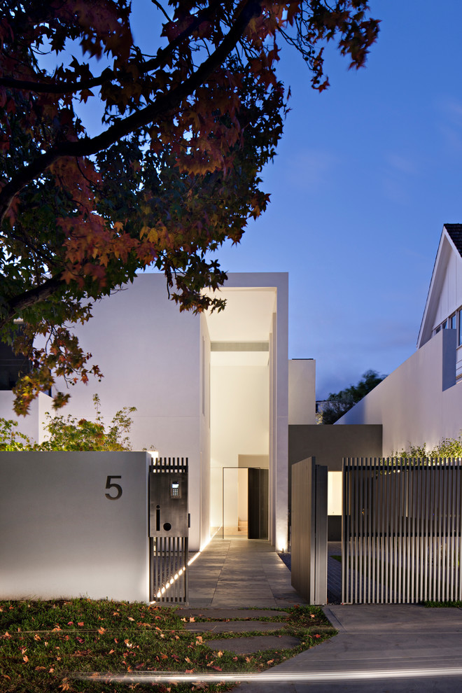 На фото: трехэтажный, белый частный загородный дом в современном стиле с облицовкой из бетона с