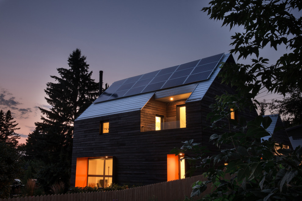 Ispirazione per la villa piccola marrone scandinava a due piani con rivestimento in legno, tetto a capanna e copertura in metallo o lamiera