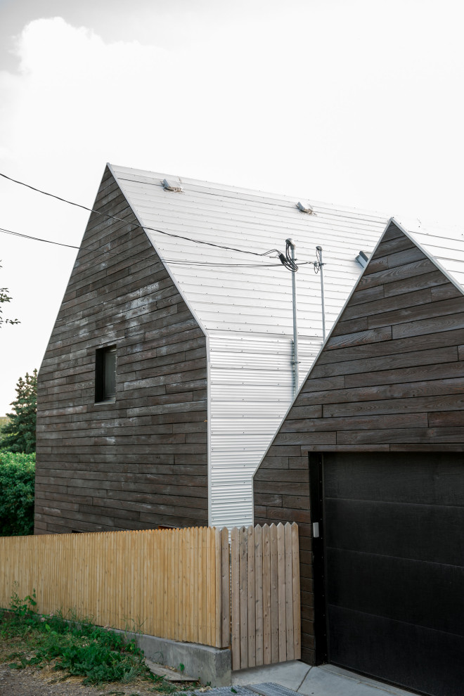 Imagen de fachada de casa marrón escandinava pequeña de dos plantas con revestimiento de madera, tejado a dos aguas y tejado de metal