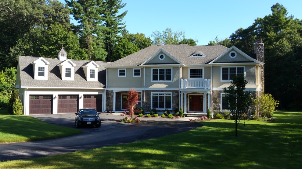 This is an example of a large and beige modern two floor house exterior in Other with mixed cladding and a pitched roof.