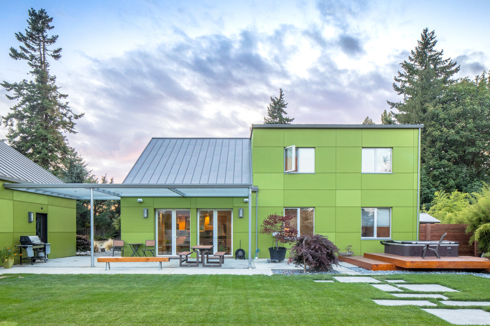 Ejemplo de fachada de casa verde bohemia de tamaño medio de dos plantas con revestimiento de aglomerado de cemento, tejado a dos aguas y tejado de metal
