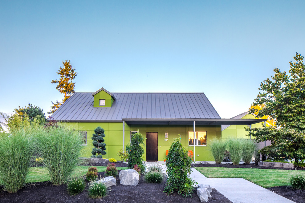 Ispirazione per la villa verde eclettica a due piani di medie dimensioni con rivestimento con lastre in cemento, tetto a capanna e copertura in metallo o lamiera
