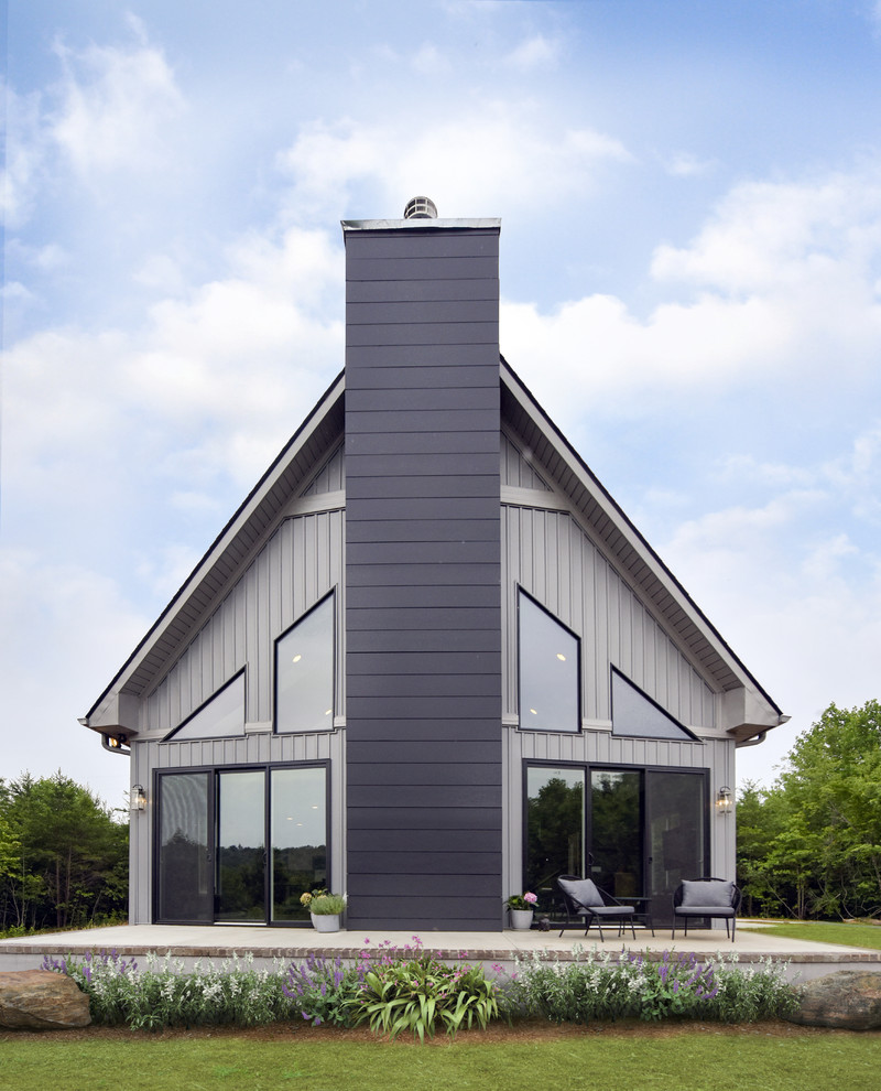 Zweistöckiges Klassisches Einfamilienhaus mit Vinylfassade, grauer Fassadenfarbe, Satteldach und Schindeldach in Sonstige