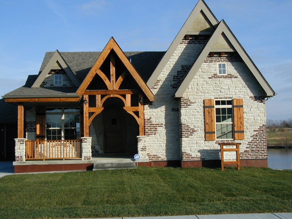 Esempio della facciata di una casa bianca rustica a un piano di medie dimensioni con rivestimento in mattoni