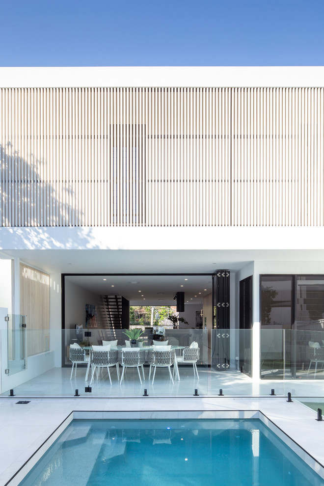 Mittelgroßes, Dreistöckiges Modernes Einfamilienhaus mit Backsteinfassade, weißer Fassadenfarbe, Satteldach und Blechdach in Brisbane