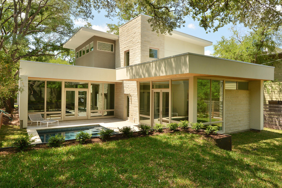 Réalisation d'une façade de maison beige minimaliste à un étage avec un revêtement mixte.