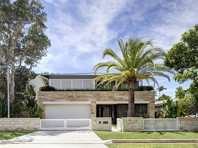 Стильный дизайн: большой, двухэтажный, бежевый дом в морском стиле с облицовкой из камня - последний тренд
