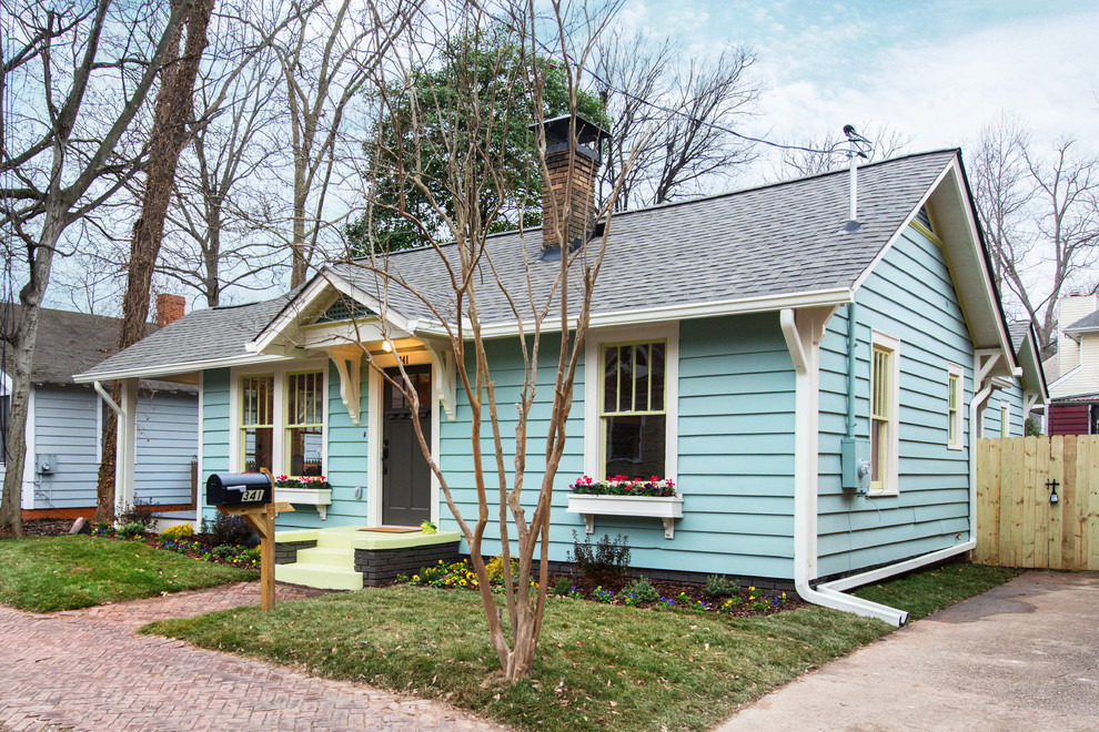Small and blue traditional bungalow house exterior in Atlanta with wood cladding.