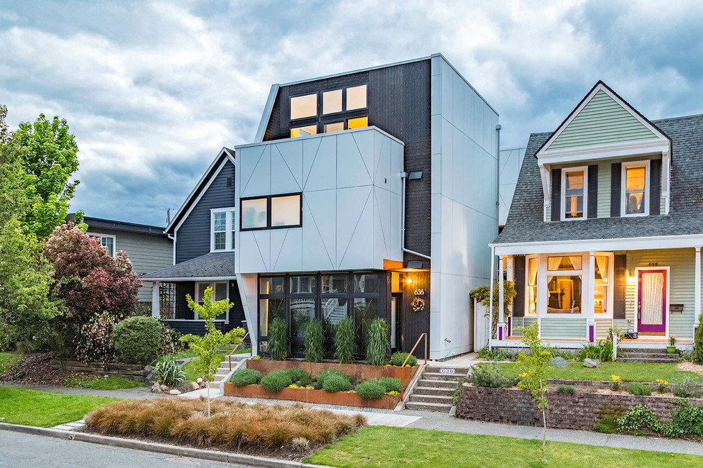 Kleine, Dreistöckige Moderne Doppelhaushälfte mit Metallfassade, schwarzer Fassadenfarbe, Flachdach und Misch-Dachdeckung in Seattle