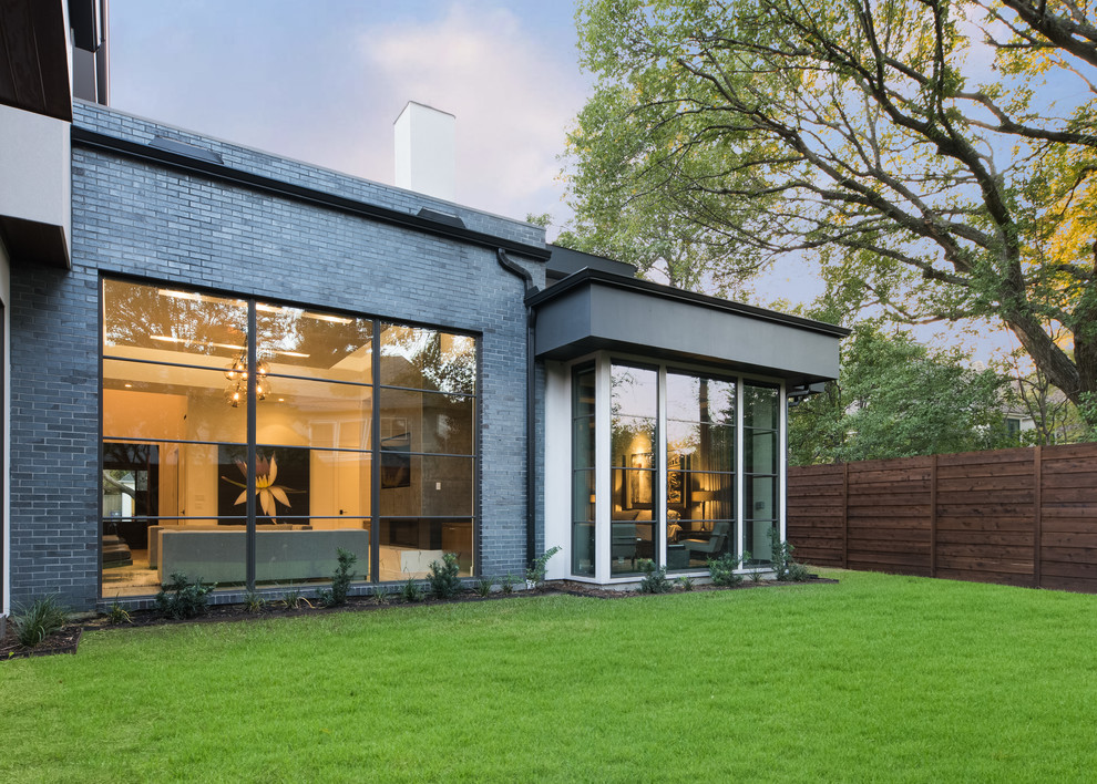 Diseño de fachada de casa negra actual de tamaño medio de dos plantas con revestimiento de aglomerado de cemento, tejado plano y tejado de varios materiales