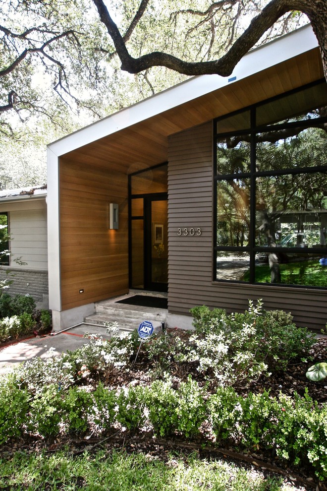 Mittelgroßes, Einstöckiges Retro Einfamilienhaus mit Mix-Fassade, grauer Fassadenfarbe, Pultdach und Blechdach in Austin